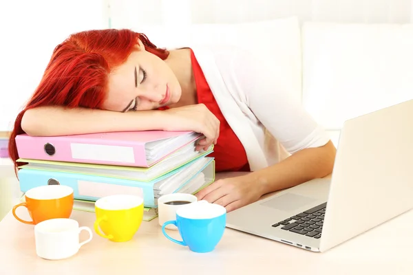 Chica cansada con cuaderno y muchas tazas duerme en la mesa —  Fotos de Stock