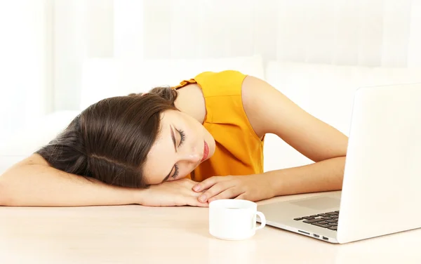 Tired girl with notebook sleeps on table — Stock Photo, Image