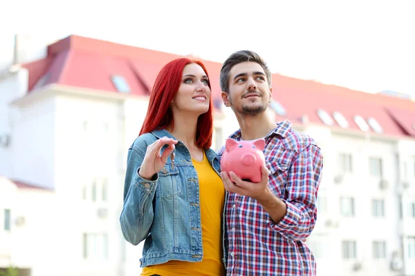 Älskande par med spargris nära apartment house — Stockfoto