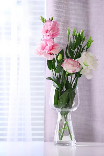 Mooie bloemen in vaas met licht uit raam — Stockfoto