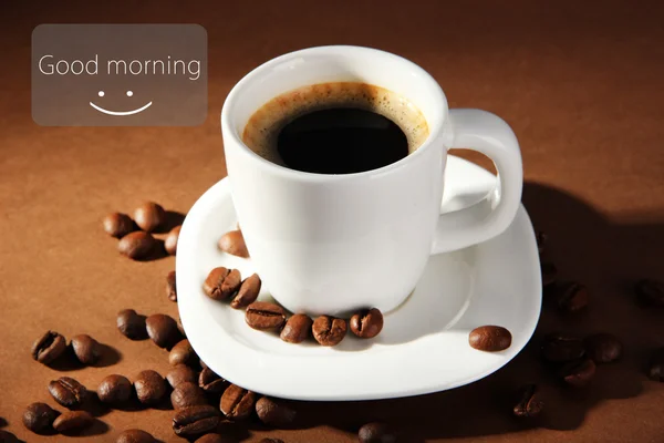 Tasse Kaffee mit Kaffeebohnen auf braunem Hintergrund — Stockfoto