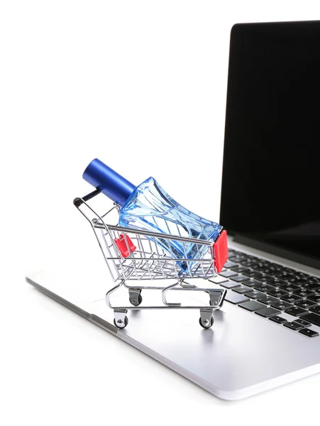 Perfume bottle on shopping cart on laptop isolated on white — Stock Photo, Image