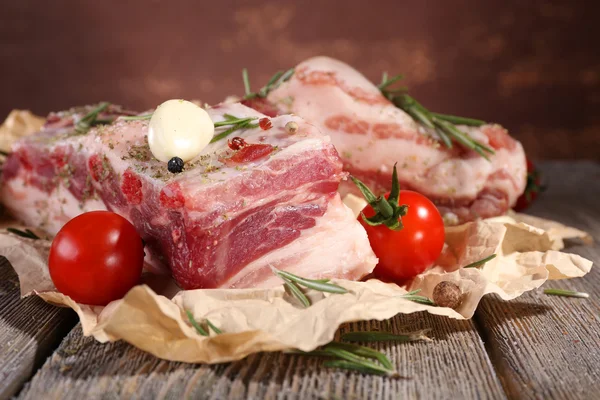 Raw bacon with spices and tomatoes on wooden table — Stock Photo, Image