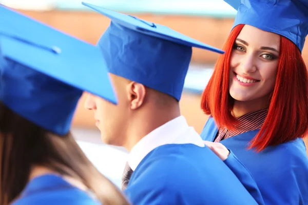 Absolwenci sobie graduacyjnej kapelusz i suknia, na zewnątrz — Zdjęcie stockowe