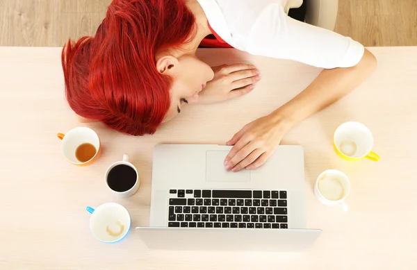 Menina cansada com notebook dorme na mesa — Fotografia de Stock