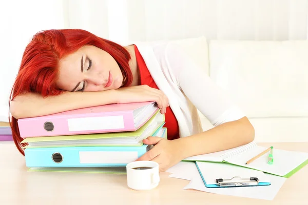 Chica cansada con muchas carpetas duerme en la mesa — Foto de Stock