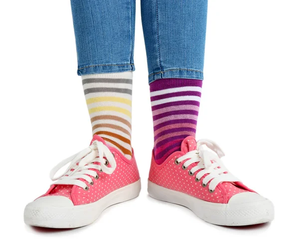 Patas femeninas en calcetines y zapatillas de deporte de colores — Foto de Stock