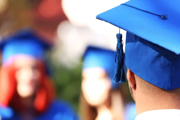 Graduate students wearing graduation hat and gown, outdoors — Stock Photo, Image