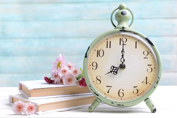 Beautiful flowers with clock and book — Stock Photo, Image