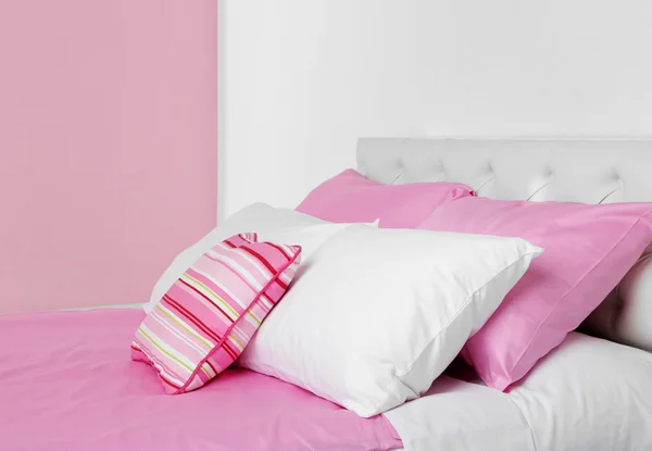 Bed in roze beddengoed — Stockfoto