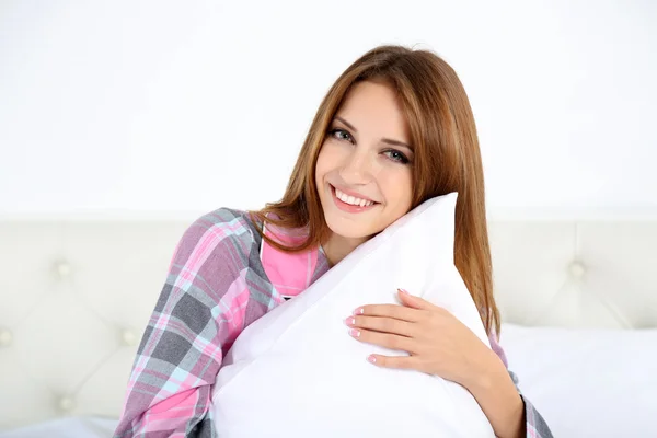 Jonge mooie vrouw zittend op bed ingedrukt te kussen — Stockfoto