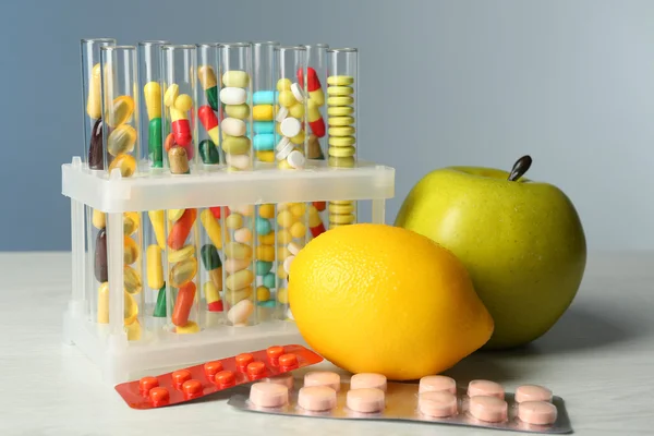 Medicamentos de color en tubos de ensayo y frutas —  Fotos de Stock