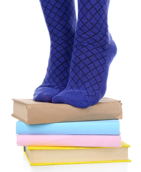 Girl in colorful socks standing on pile of books — Stock Photo, Image