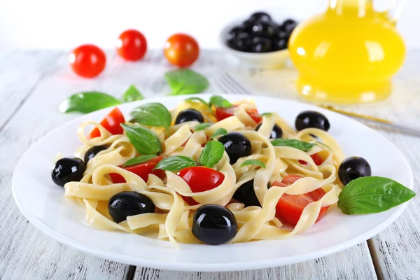 Спагетті з помідорами, оливками та листям базиліка — стокове фото