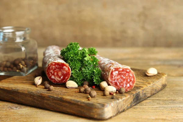 Salami italiano sobre tabla de cortar de madera — Foto de Stock