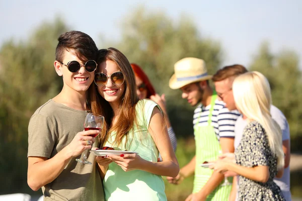 Young couple with friends on rest, outdoors — Stock Photo, Image