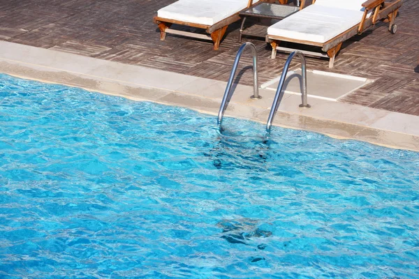 Ligstoelen in de buurt van zwembad — Stockfoto
