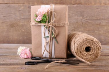 güzel hediye çiçek ve eski ahşap zemin üzerinde dekoratif ip ile