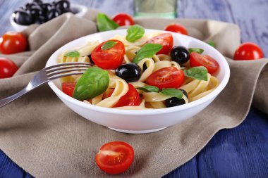 Spagetti domates, zeytin ve fesleğen yaprakları ile