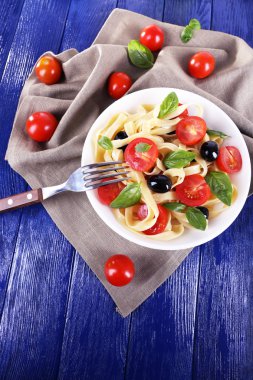 Spagetti domates, zeytin ve fesleğen yaprakları ile