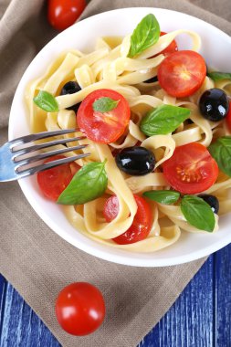 Spagetti domates, zeytin ve fesleğen yaprakları ile