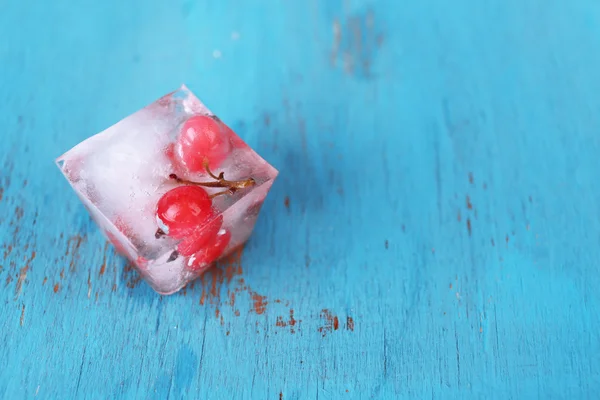 Cubi di ghiaccio con ribes rosso, su fondo di legno — Foto Stock