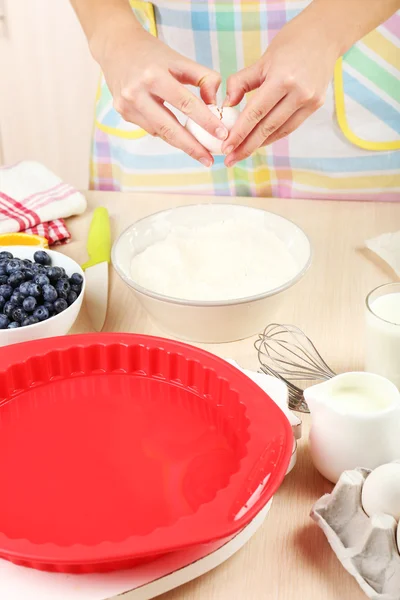 Выпечка вкусный пирог и ингредиенты для него на столе на кухне — стоковое фото