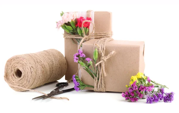 Hermosos regalos con flores y cuerda decorativa, aislados en blanco — Foto de Stock