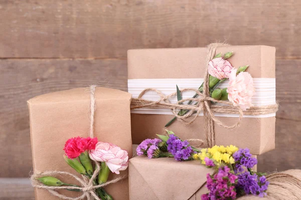 Красиві подарунки з квітами на старому дерев'яному тлі — стокове фото