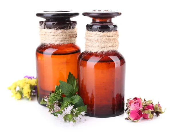 Aceite esencial con diferentes plantas medicinales, aislado en blanco — Foto de Stock