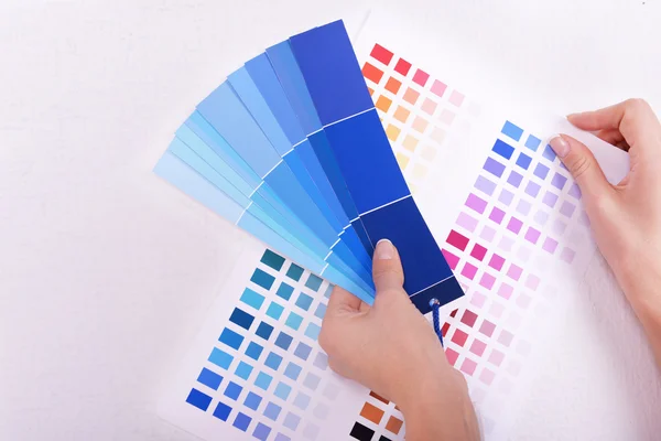 Woman choosing color for wall from swatches in room — Stock Photo, Image