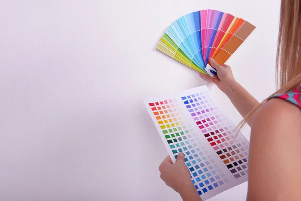 Frau wählt Farbe für Wand aus Mustern im Zimmer — Stockfoto