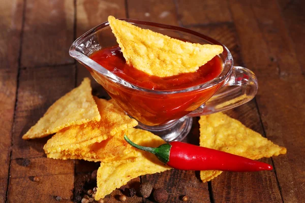 Nachos saborosos e tigela com molho — Fotografia de Stock