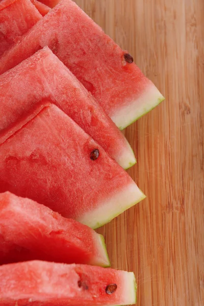 Slices of watermelon on wooden background — Stock Photo, Image