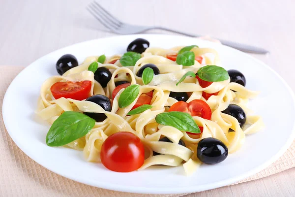 Espaguete com tomate, azeitonas e folhas de manjericão — Fotografia de Stock