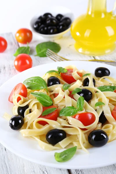 Espaguetis con tomates, aceitunas y hojas de albahaca —  Fotos de Stock