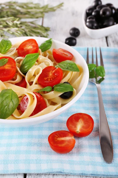 Spaghetti with tomatoes, olives and basil leaves — Stock Photo, Image