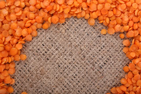 Lentilha de laranja sobre pano de saco — Fotografia de Stock