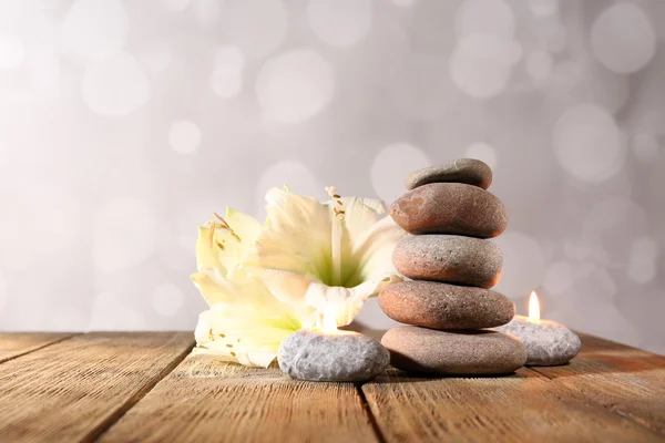 Piedras de spa, vela y orquídea blanca — Foto de Stock