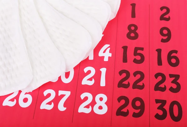 Serviettes hygiéniques sur calendrier rouge — Photo
