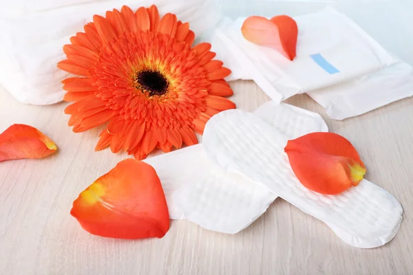 Tampons hygiéniques, fleur orange et pétales de rose — Photo