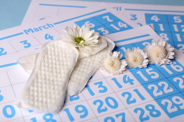 Almohadillas sanitarias y flores blancas — Foto de Stock