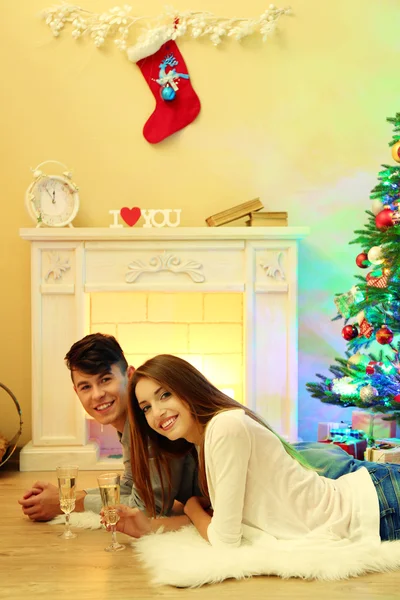 Casal feliz tendo bebidas por lareira na acolhedora sala de estar escura na véspera de Natal — Fotografia de Stock
