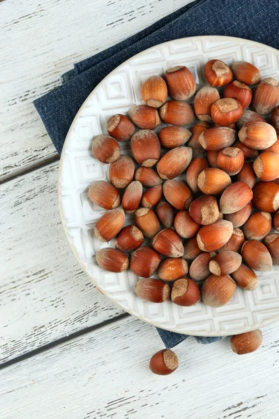 Hazelnuts in plate on napkin — Stock Photo, Image