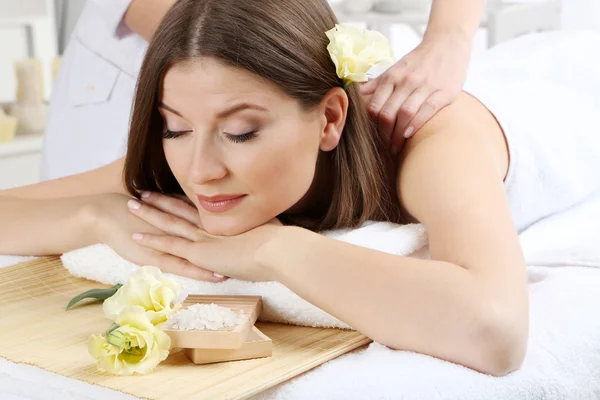 Krásná mladá žena s masáží v salonu spa — Stock fotografie