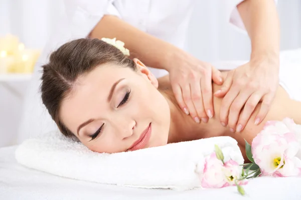 Mooie jonge vrouw met massage in de spa salon — Stockfoto