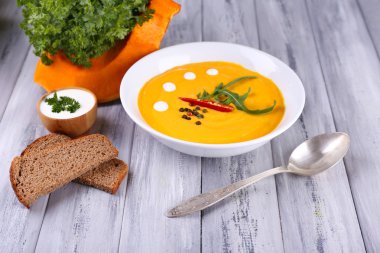 Beyaz plaka ve kabak dilim, ekmek, ahşap arka plan balkabağı çorbası