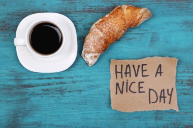 Kahve, taze kruvasan ve kağıt kartı