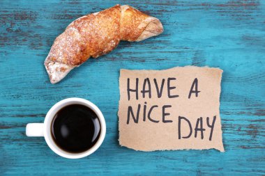 Kahve, taze kruvasan ve kağıt kartı