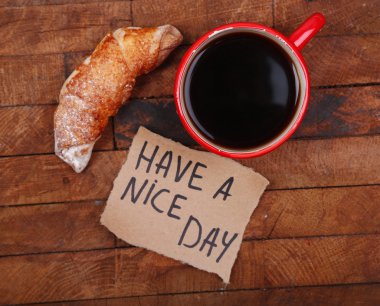 Kahve, taze kruvasan ve kağıt kartı